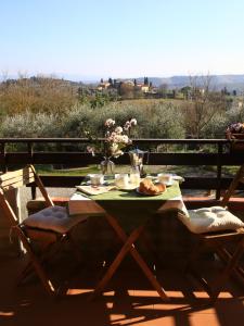 einen Tisch mit einem Teller Essen und Blumen darauf in der Unterkunft Casa Milena in San Gimignano