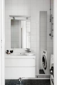 a bathroom with a sink and a washing machine at Urban Trendy Nordic Living in Helsinki