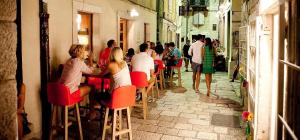 eine Gruppe von Menschen, die in einer Gasse an einer Bar sitzen in der Unterkunft MK Luxury Rooms in Split