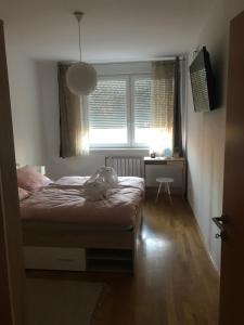 a bedroom with a bed and a desk and a window at Apartment Marlena in Zagreb