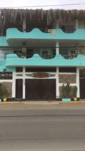 un edificio azul al lado de una calle en La Tablita, en Zorritos