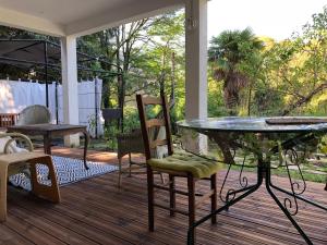 een patio met een glazen tafel en stoelen op een terras bij La Sala in Amélie-les-Bains-Palalda