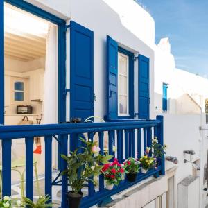 eine blaue Tür und einige Blumen auf dem Balkon in der Unterkunft Izabela's House Mykonos Town in Megali Ammos