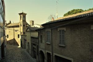 an alley with a building and a clock tower at Home in Ravenna
