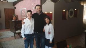 a man and two children posing for a picture at Xenonas Sta Tzakia in Karpenisi