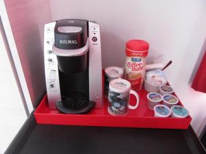 uma cafeteira numa prateleira vermelha num frigorífico em Hostellerie du Suroît em Beauharnois