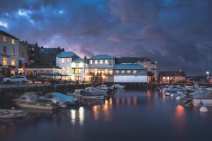 un grupo de barcos atracados en un puerto por la noche en Chainlocker en Falmouth