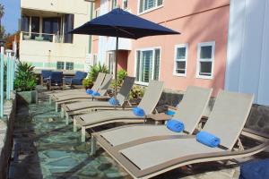 een rij ligstoelen met een parasol op een patio bij Venice on the Beach Hotel in Los Angeles