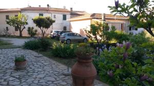a garden with flowers and a yard with a building at Casa di Giulia (Bambini gratis fino a 6 anni) in Santa Luce