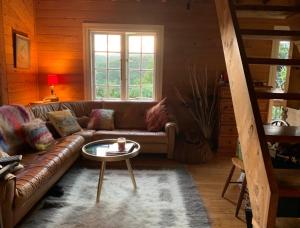 uma sala de estar com um sofá e uma mesa em Whalers Cottage na Ilha da Grande Barreira
