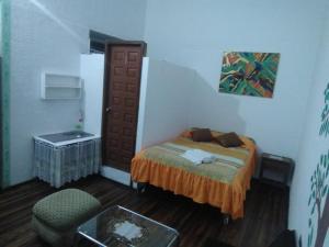 1 dormitorio pequeño con 1 cama y 1 silla en San Marcos Cultural & Guesthouse, en Quito