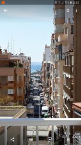 vista su una strada della città con auto parcheggiate di Apartamentos Centro a Santa Pola