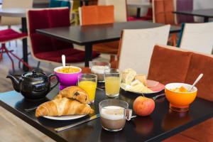 a table with breakfast foods and drinks on it at Brit Hotel Codalysa Marne la Vallée - Torcy in Torcy