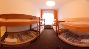 a room with three bunk beds and a window at Penzion Heřmanice in Králíky