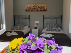 two beds in a room with purple flowers in the foreground at Apartamento El Sauce de Amalia in Celorio