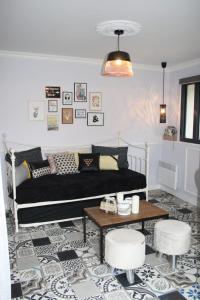 sala de estar con sofá negro y mesa en le petit boudoir, en Annet-sur-Marne