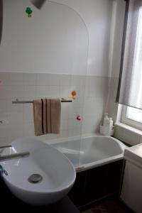 uma casa de banho branca com um lavatório e uma banheira em Appartement 3 pièces, Krutenau, Parking privé em Estrasburgo