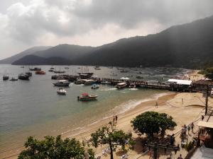 a group of boats in the water near a beach at Pousada Agua Viva in Abraão