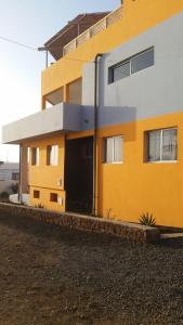 a yellow and white house with a driveway at Casa Patio in Tarrafal