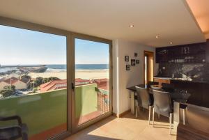 a room with a balcony with a view of the ocean at João Beach House in Leça da Palmeira