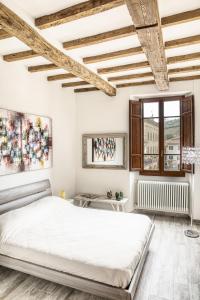 Il Nido nel Chianti في غريفي ان شنتي: غرفة نوم بيضاء مع سرير كبير ونافذة