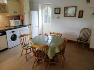 una cucina con tavolo, sedie e forno a microonde di Tig Rua a Killarney