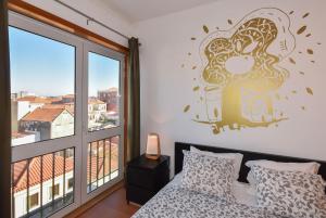 Un dormitorio con una cama y una ventana grande en João Beach House, en Leça da Palmeira