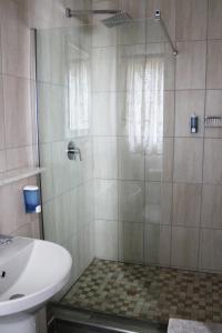 y baño con ducha y lavamanos. en Omaruru Guesthouse en Omaruru