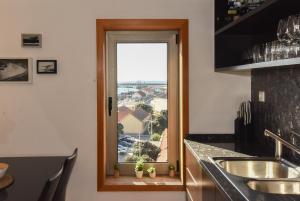 una cocina con una ventana con plantas en un mostrador en João Beach House, en Leça da Palmeira 57 fotos más