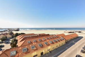 Una vista aérea de un edificio y la playa. en João Beach House, en Leça da Palmeira