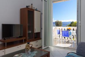 a living room with a tv and a sliding glass door at Apartments in Vrbnik/Insel Krk 36771 in Vrbnik