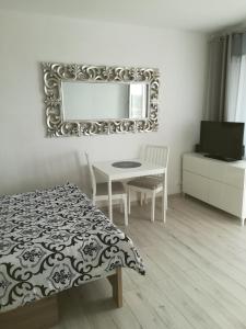 Schlafzimmer mit einem Tisch und einem Spiegel an der Wand in der Unterkunft Iwona in Świnoujście