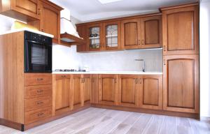 una grande cucina con armadi in legno e lavandino di SAN - Luxury Apartment a Santa Maria di Castellabate