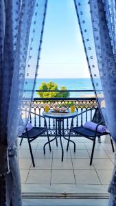 a table on a balcony with a view of the ocean at Bel Momento in Alikanas