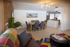 a living room with a couch and a table and chairs at Mae's Lodge in Birchington