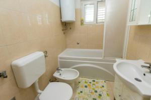 ein Badezimmer mit einem WC, einem Waschbecken und einer Badewanne in der Unterkunft Apartment Linda in Primošten