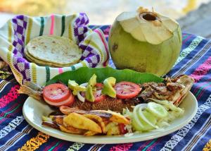 a plate of food with a sandwich and vegetables at Mayan Spirit in Flores