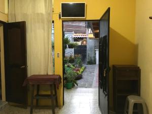 an open door to a hallway with a table and a stool at Casa Josefa Hotel in Santiago Atitlán
