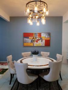 a dining room with a table and chairs and a chandelier at Beautiful azelia elite guesthouse at bukit banyan sungai petani in Sungai Petani