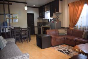ein Wohnzimmer mit Sofa und Tisch und eine Küche in der Unterkunft JCGA Apartments (Angelo's Burnham) in Baguio City
