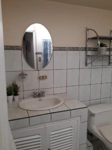 a bathroom with a sink and a mirror at Kubo Apartment in Alajuela City