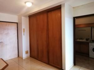 un pasillo con una puerta de madera en una casa en Tahiti - Le Condo Ariitea, en Pirae