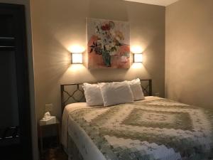 a bed with two pillows and a painting on the wall at Riverside Hot Springs Inn & Spa - Adults Only in Lava Hot Springs +30 photos