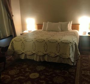 a bedroom with a white bed with two pillows at Riverside Hot Springs Inn & Spa - Adults Only in Lava Hot Springs