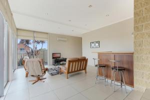 a living room with chairs and a couch and a television at Nautilus in Lakes Entrance