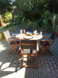 a wooden table with two chairs and a keyboard on it at Cherrywood Cottage in Akaroa