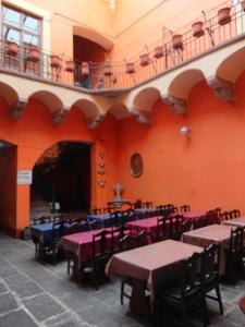 a room with tables and chairs and a balcony at Suite Valentina in Puebla