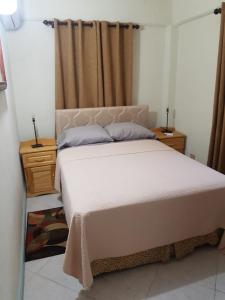 a bedroom with a large white bed and two night stands at Breezy Apts in Saint Philip