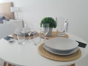 a white table with a plate and glasses on it at Departamento sobre el Rio. in Corrientes