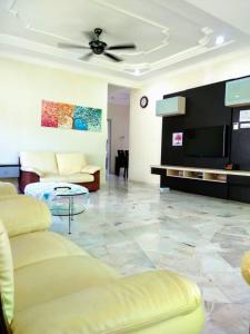 un soggiorno con divano e TV a schermo piatto di Lot 4 PD Villa a Port Dickson
